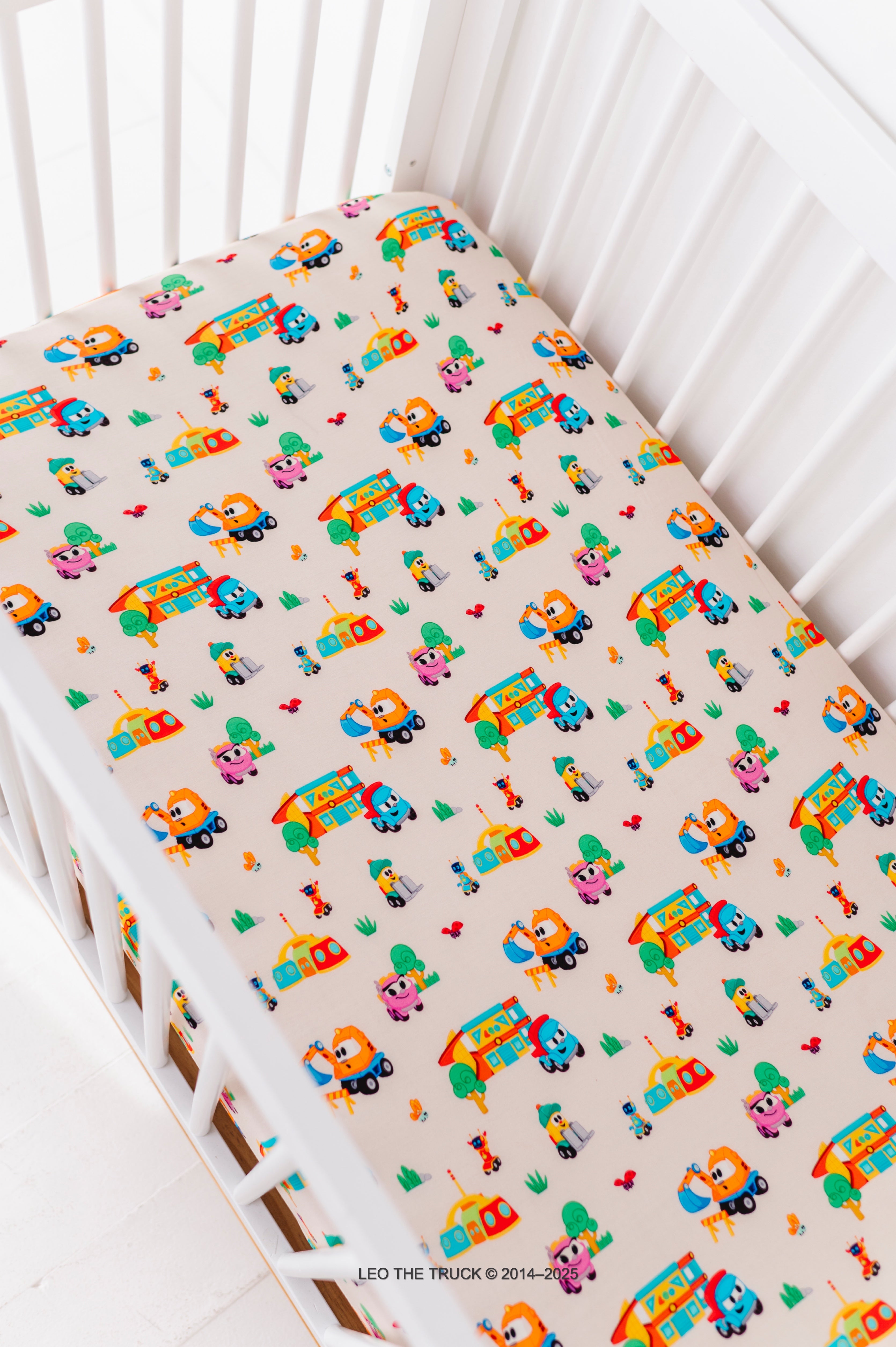 White crib with a Leo the Truck bamboo fitted crib sheet